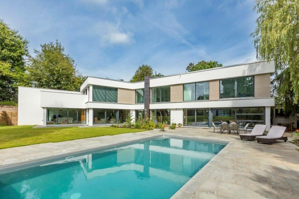 Hausbeispiel von Meisterstück-Haus, großzügige Villa im Bauhausstil auf 2 Ebenen, Gartenansicht mit Pool, Hausbau mit Frau Fertighaus
